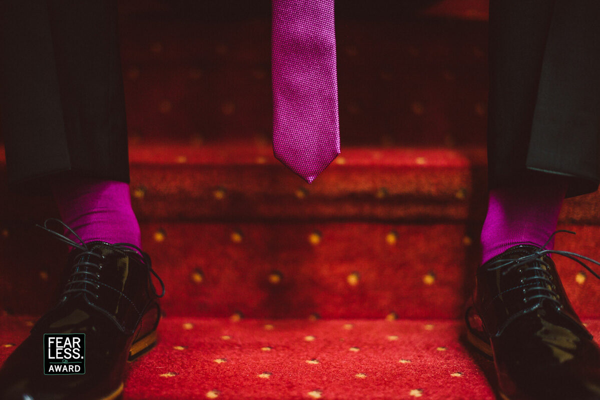 Lila Socken und Krawatte des Bräutigams auf rotem Teppich — Fearless Award